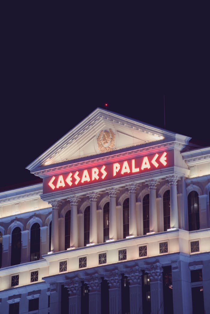 Elegant neon-lit Caesars Palace building in Las Vegas at night.